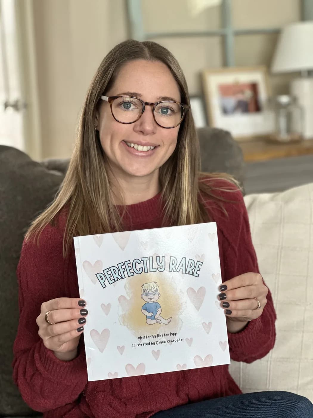 Kirsten Pipp holding Perfectly Rare, the children's book she wrote